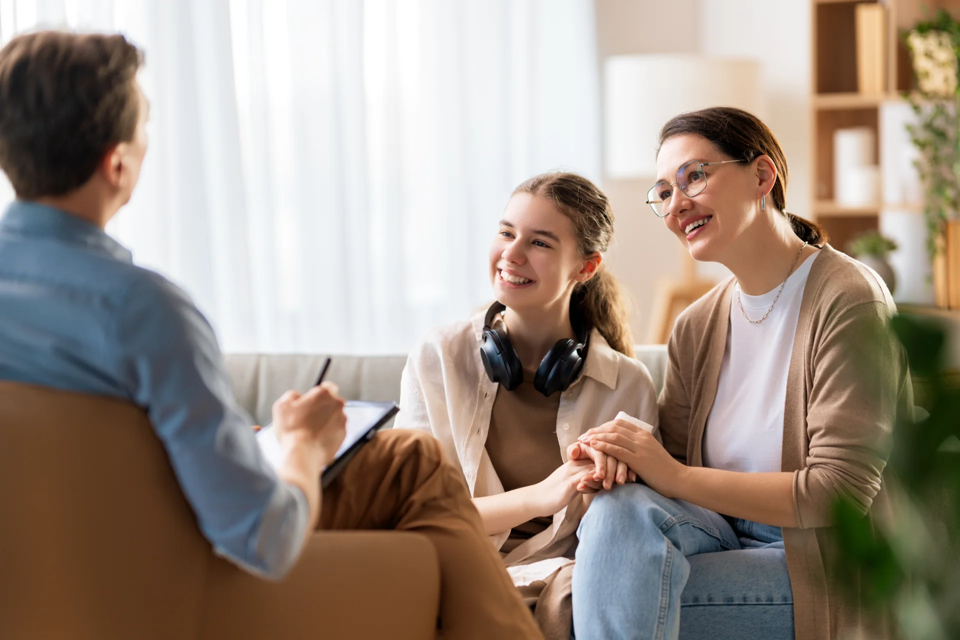 A teenage girl and her mother talking with a therapist